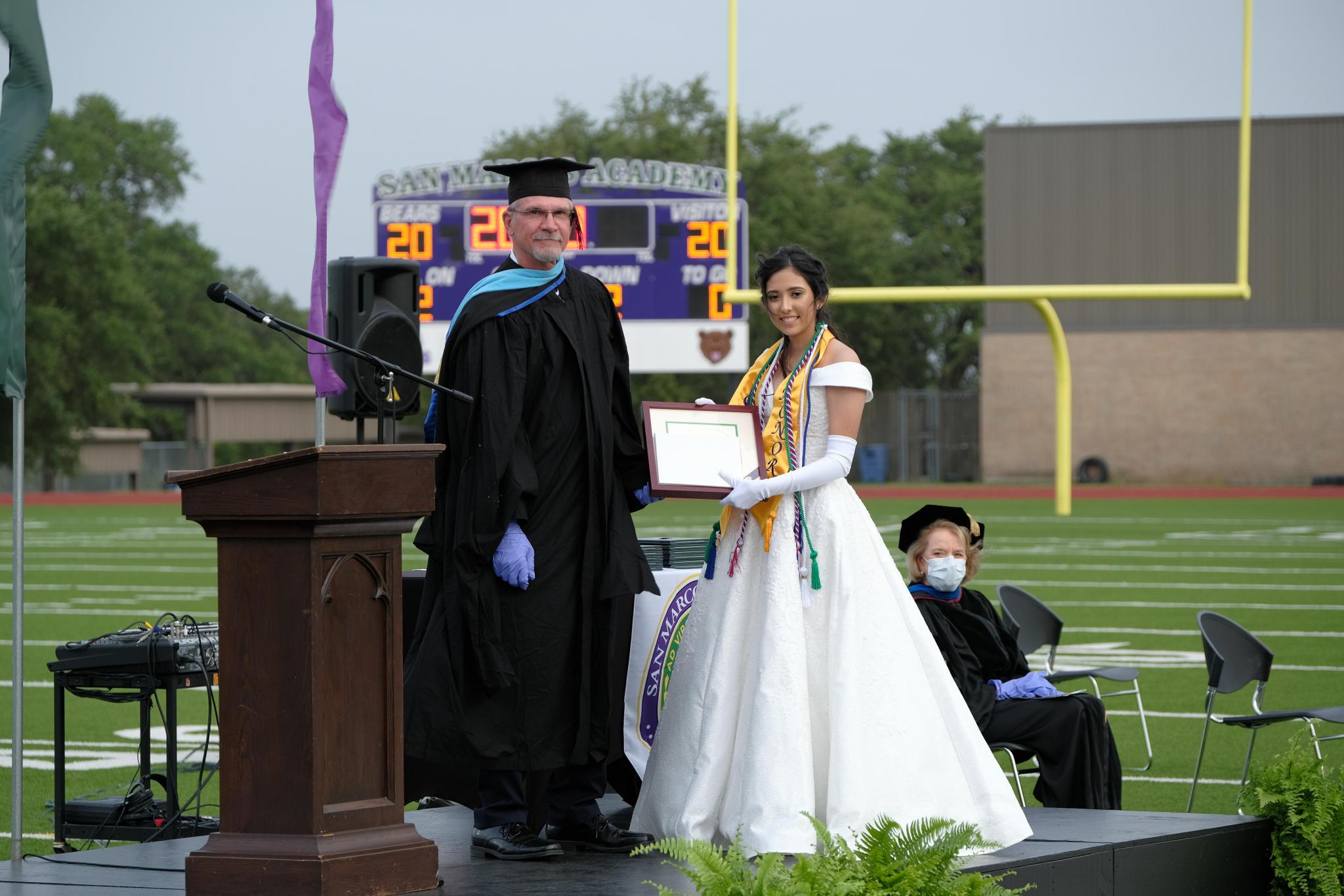Cendra Rodriguez of San Marcos receives the salutatorian award from Bob Wiegand, SMA Senior Vice President, before giving her speech at Commencement. Rodriguez will attend Baylor University in the fall to major in biology on a pre-med track.